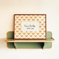 Decorative wall shelf with a framed print featuring heart patterns and text on a beige background