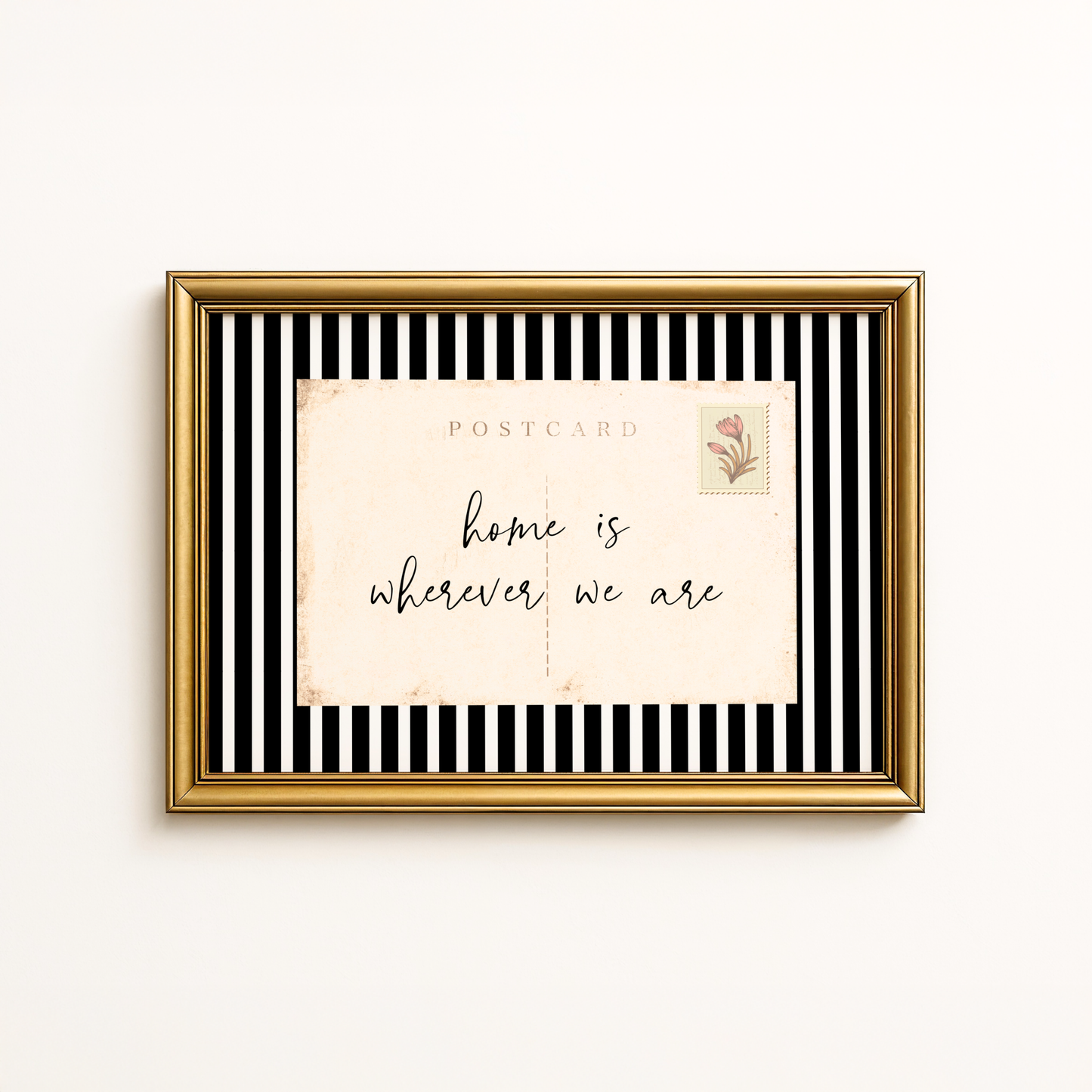 Framed postcard with 'home is wherever we are' text on a black and white striped background