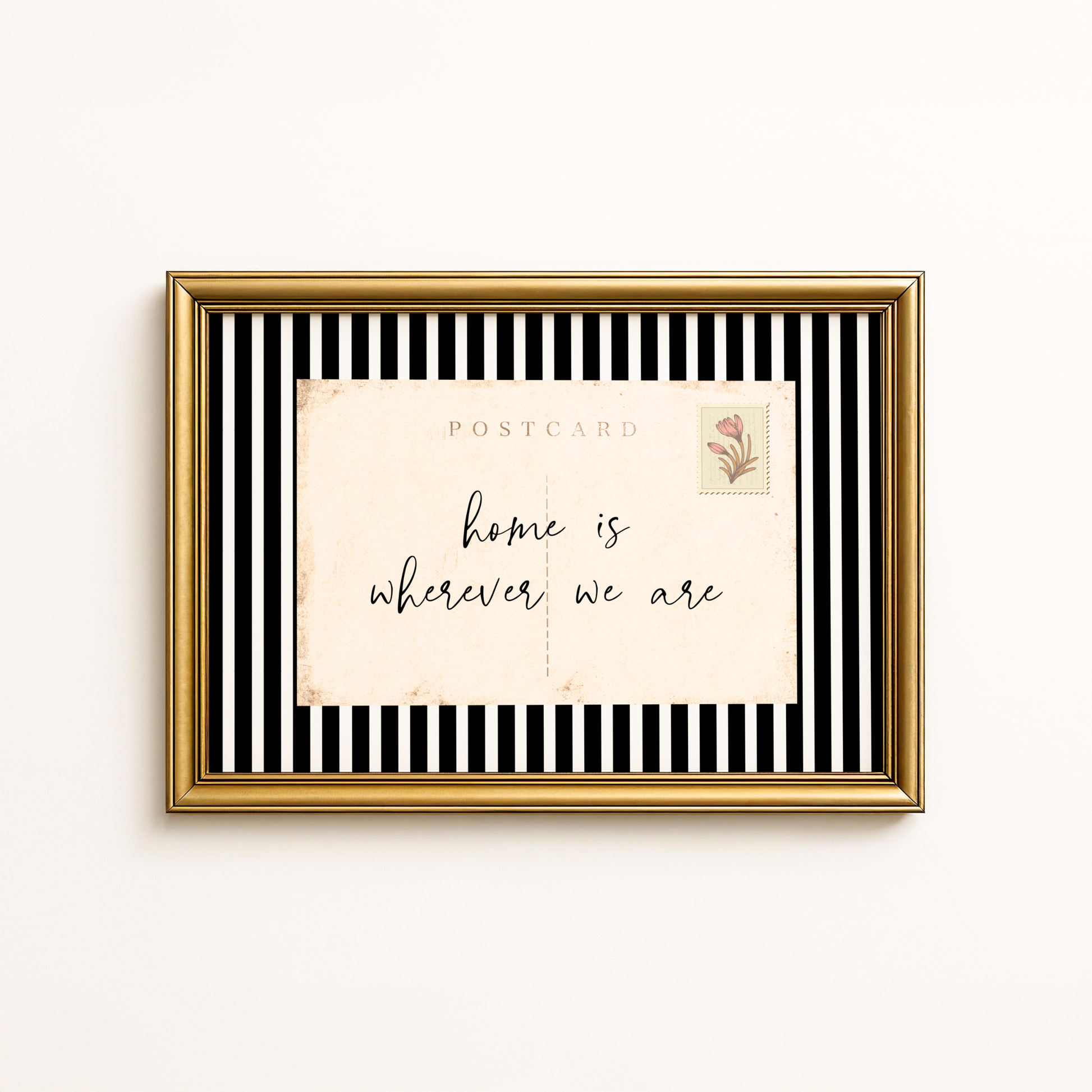 Framed postcard with 'home is wherever we are' text on a black and white striped background