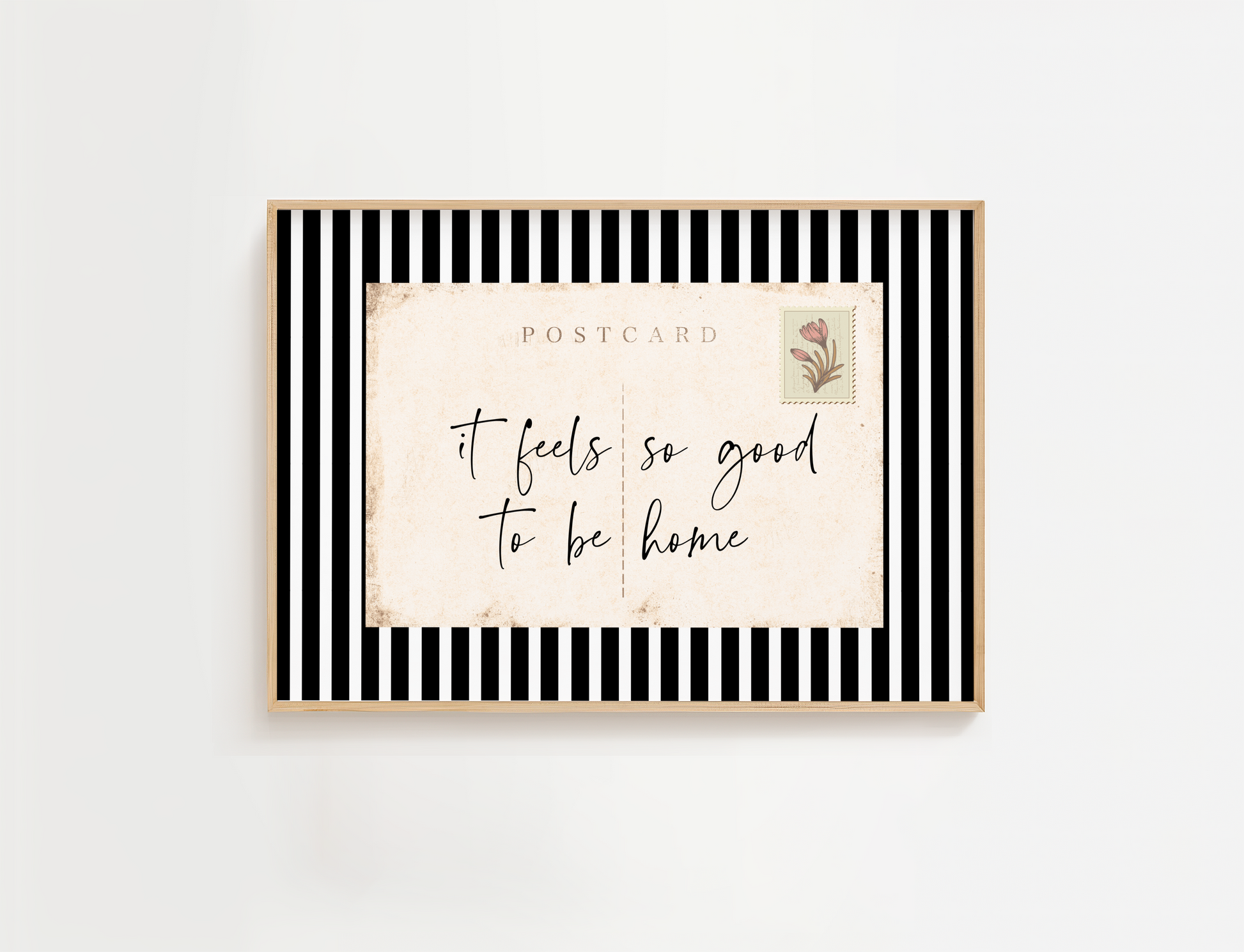 Framed postcard with 'it feels so good to be home' text on a white background