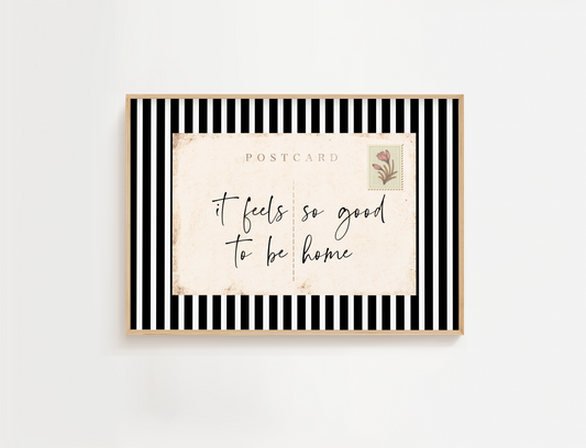 Framed postcard with 'it feels so good to be home' text on a white background