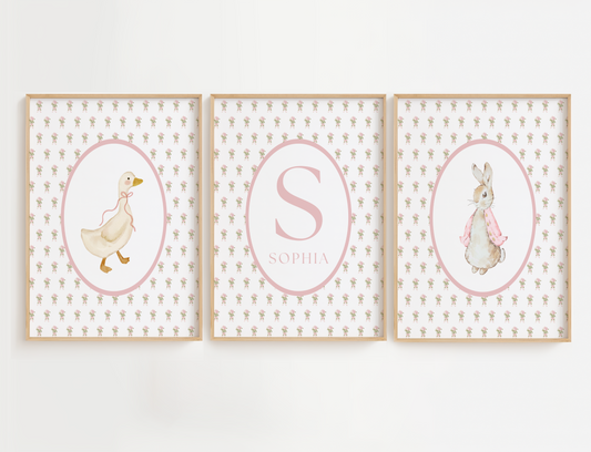 Flower nursery wall art featuring delicate pink flowers and a vintage goose, vintage peter rabbit, and a nursery name sign. Nursery wall art set for a baby girl room.