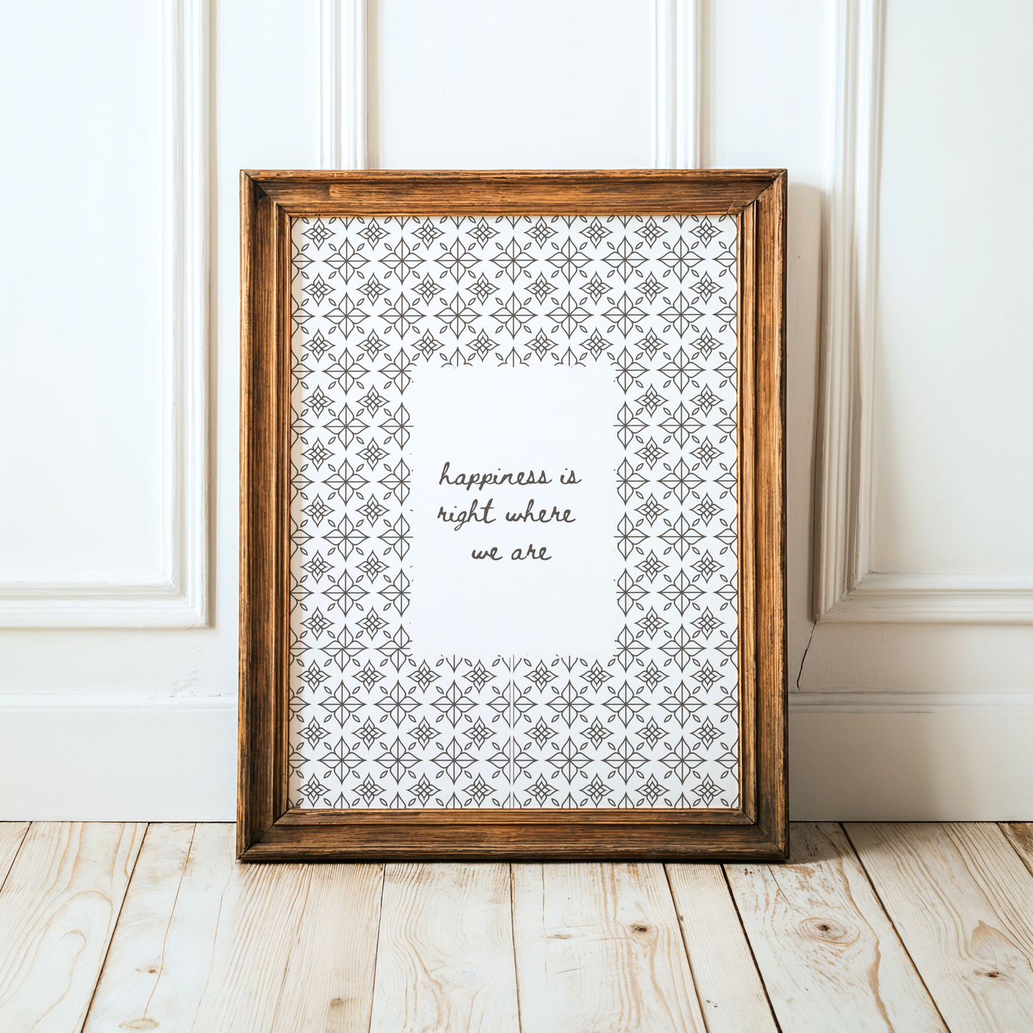 Framed print with decorative pattern and text on a wooden floor.