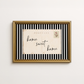 Framed artwork with 'home sweet home' text on a striped background