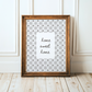Framed print with 'home sweet home' text on a white background, leaning against a white wall.