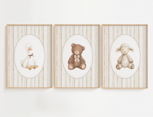 Three framed illustrations of a duck, bear, and sheep on a white wall.