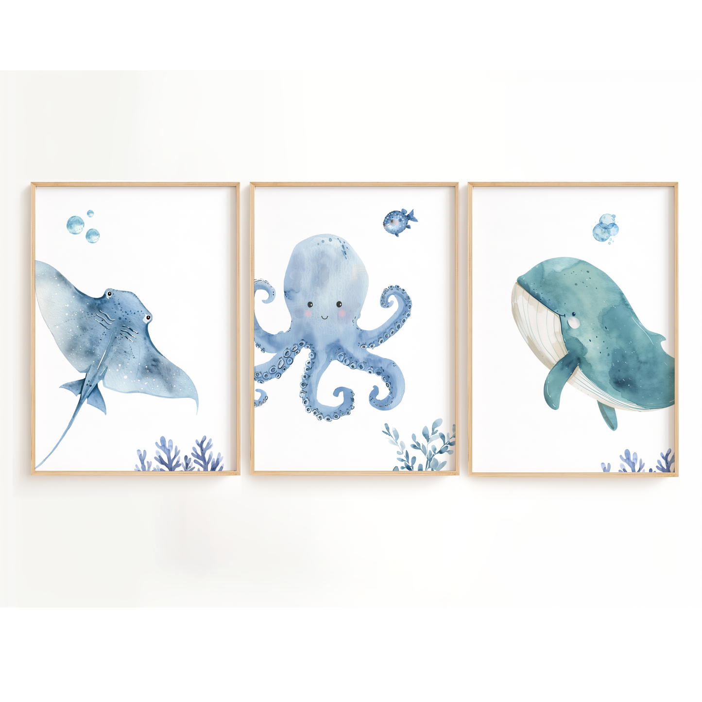 Three framed watercolor-style nursery wall art prints showing an octopus, a whale, and a ray on a white background, hung side by side on a light wall.