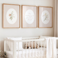 Nursery room with a crib, teddy bear, and wall art featuring floral and text designs.