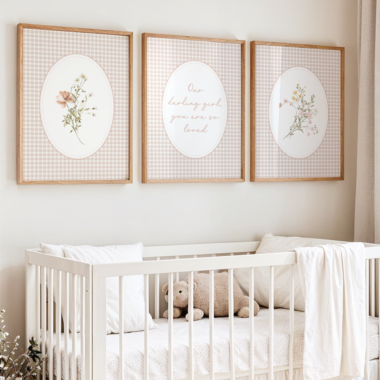 Nursery room with a crib, teddy bear, and wall art featuring floral and text designs.