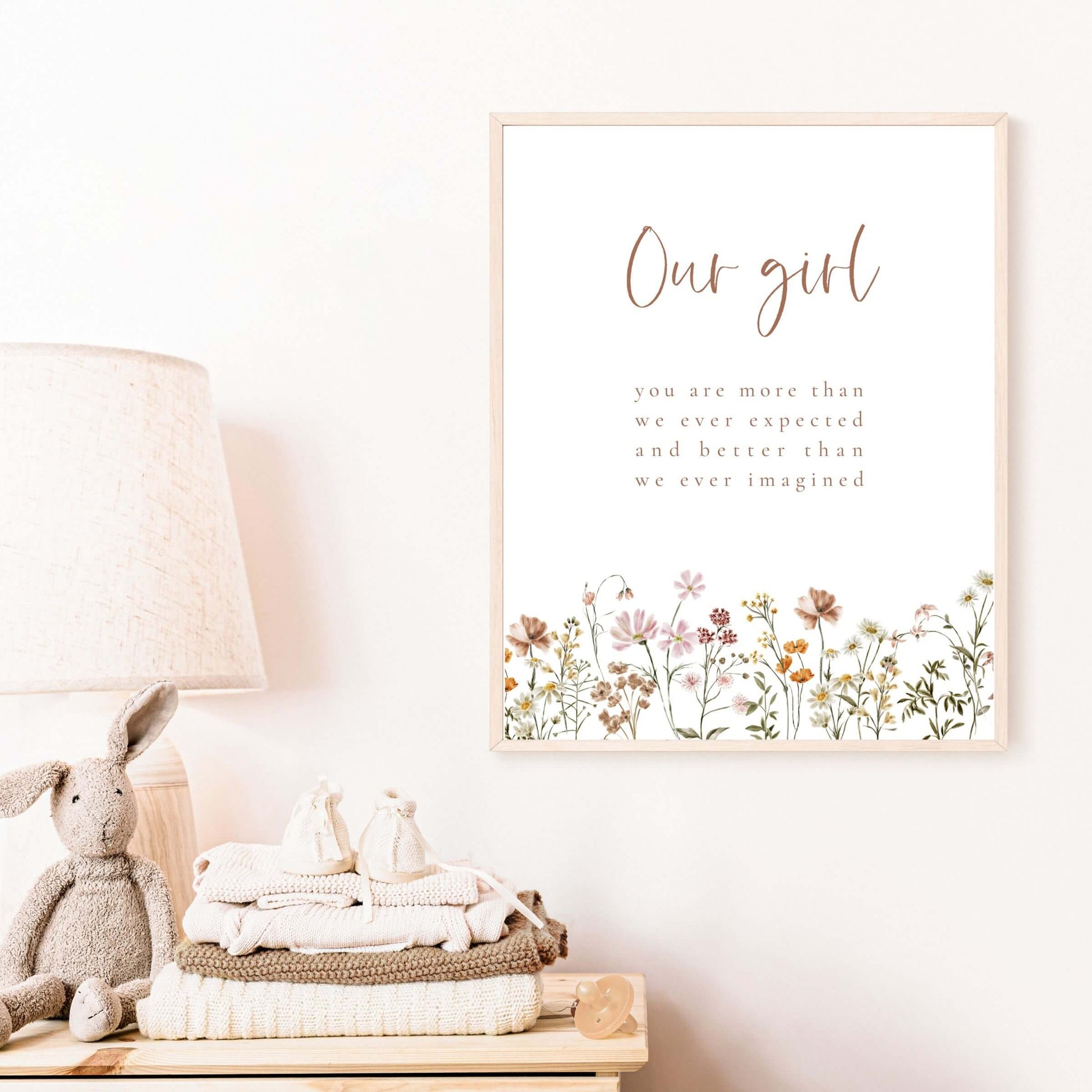 Our girl wall art with wildflowers in a wood frame hanging on the wall in a nursery