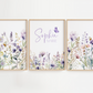 Three framed watercolor floral prints hang on a white wall. The center print features the names 'Sophia' and 'MARIE' in purple script, while the left and right frames show pastel wildflowers with a small butterfly in each design.