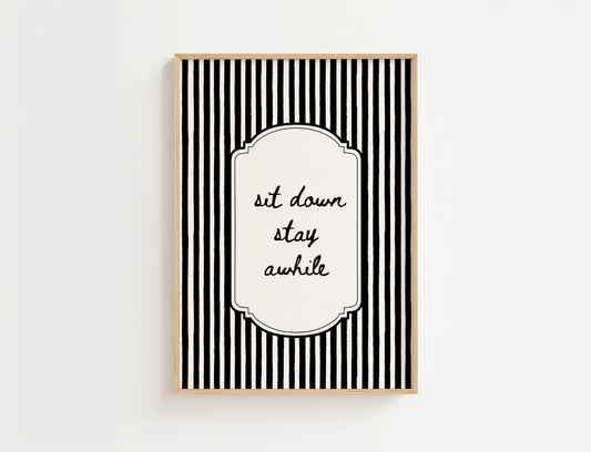 Framed black and white striped wall art with 'sit down stay awhile' text on a white background