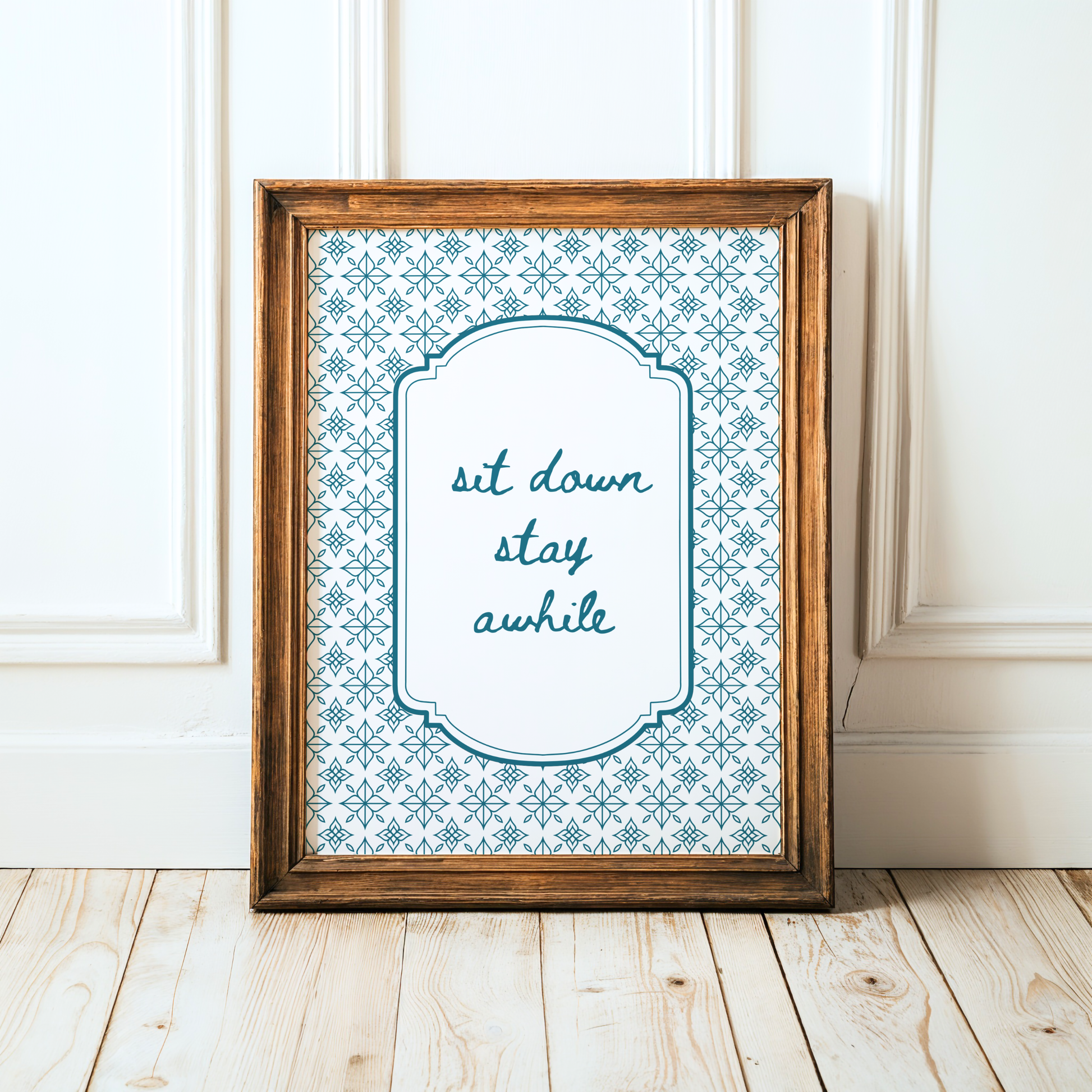 Framed print with 'sit down, stay awhile' text on a decorative background