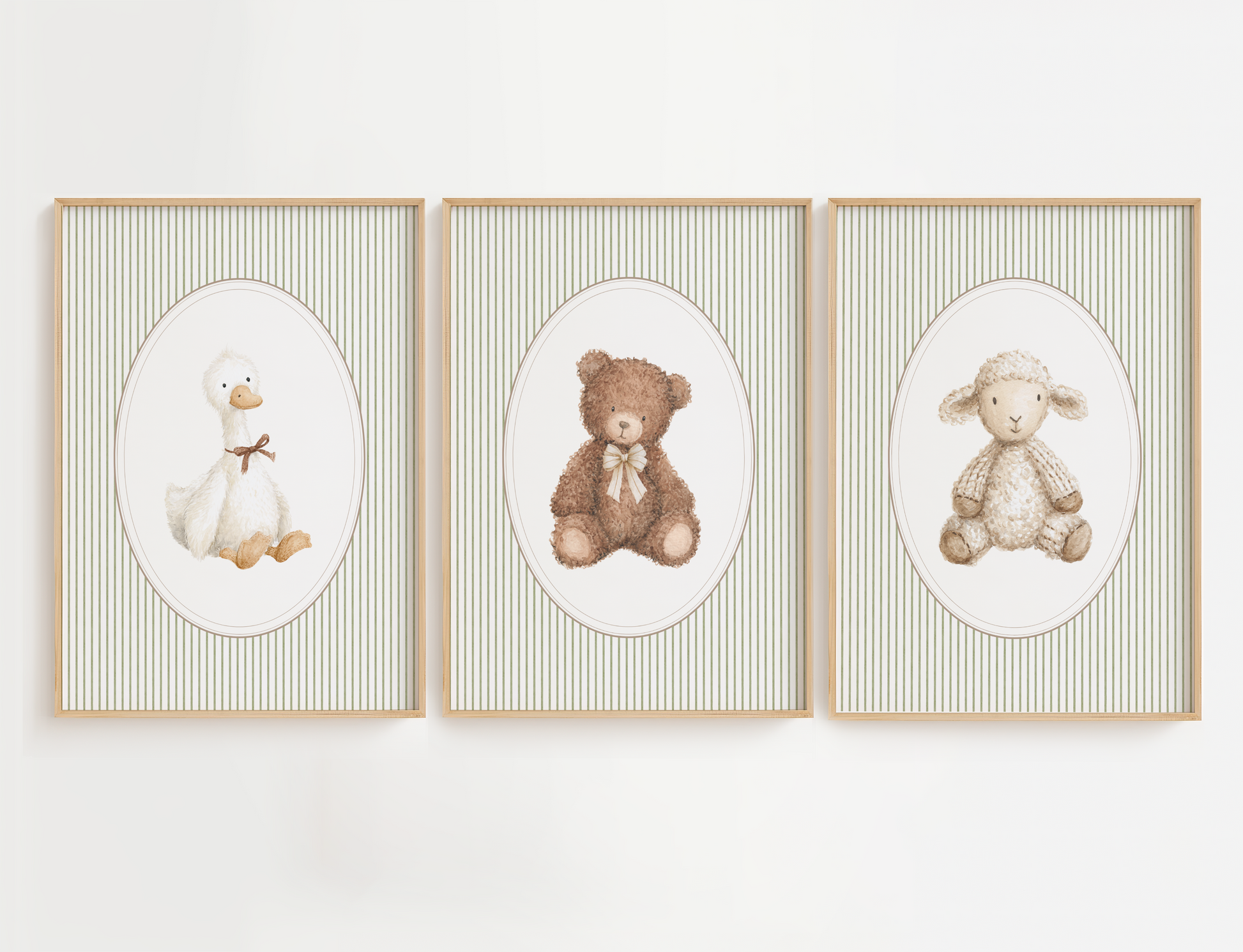 Three framed nursery art prints hanging side-by-side on a white wall. Each print features a soft, textured illustration of a baby animal (a duck, a teddy bear, and a lamb) inside an oval, set against a background of thin vertical stripes in beige and white, all enclosed in light wood frames.