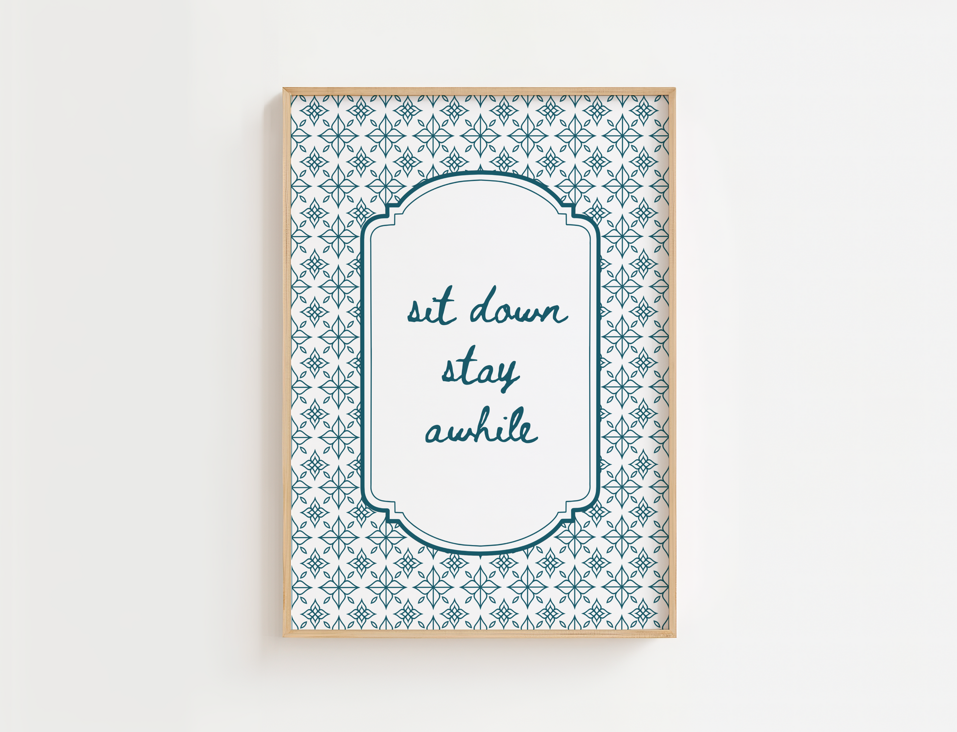Decorative wall art with patterned border and text 'sit down stay awhile' on a white background